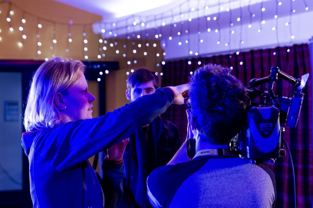 Production photograph showing members of the technical team adjust =ing equipment settings.