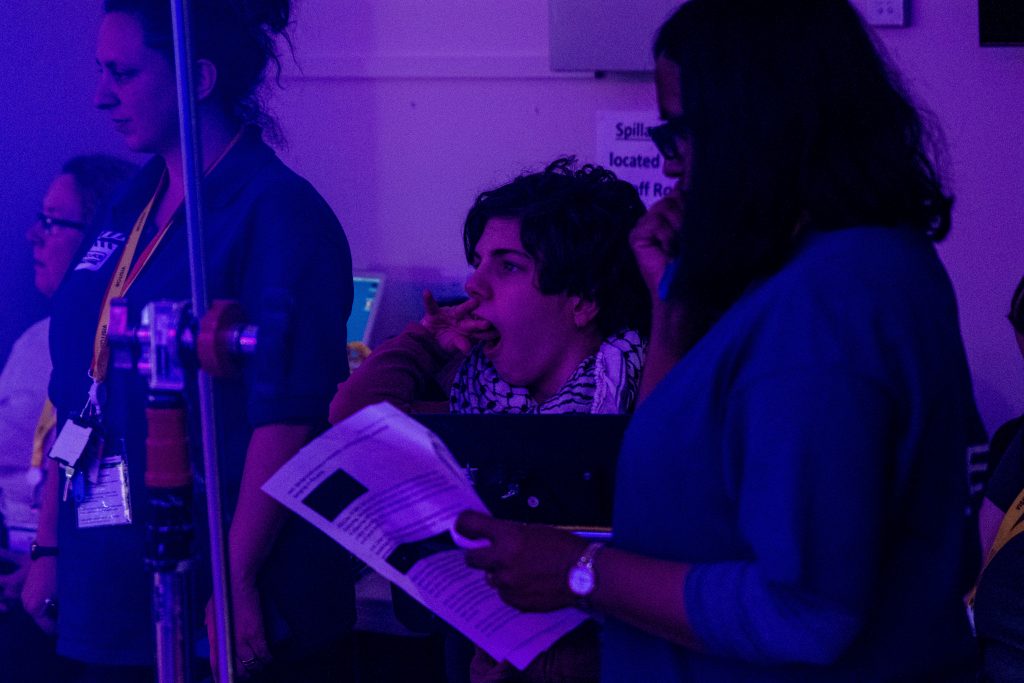 Production photograph showing director and other members of the team looking at the action.